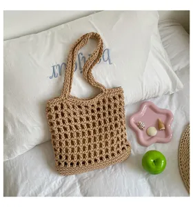 Vue détaillée du sac cabas d'épaule ajouré en coton beige dans une scène de style décontracté.