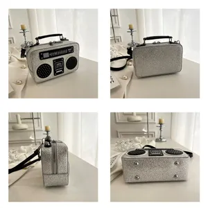 Silberne Glitzer Boombox Umhängetasche mit schwarzem Griff und Retro Radio Front Design.