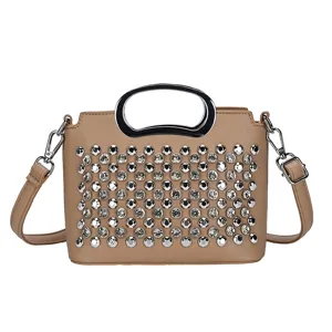 Vue détaillée du sac à main kaki orné de strass avec une poignée supérieure métallique.