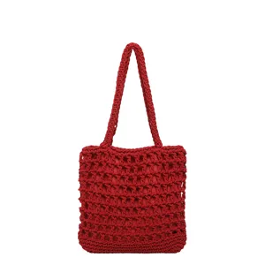 Vue rapprochée de la texture en maille ajourée rouge et de la solide bandoulière chic.