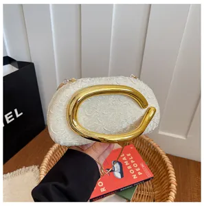 Chic irregular evening bag with bold gold C-handle, elegant white texture clutch for women.
