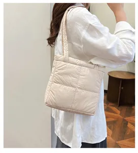 Detail view of a beige quilted shoulder underarm bag, soft cotton fabric, casual daily look.
