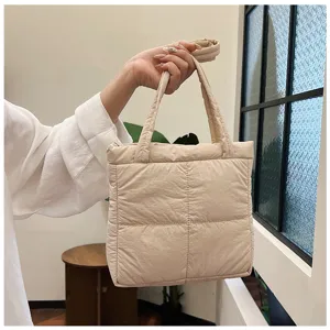Close-up shot of casual quilted tote shoulder bag in elegant beige style for women.