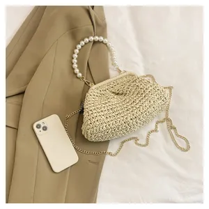 Chic straw woven handbag featuring elegant pearl handle and gold chain strap, perfect for vacation.