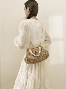 Straw woven crossbody bag with pearl handle and gold chain for women summer beach vacation style.