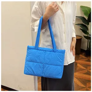 Blue puffer tote bag for women, quilted casual shoulder bag, stylish autumn commute handbag.