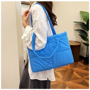 Blue quilted puffer shoulder bag, soft padded daily tote, casual minimalist commuter style.