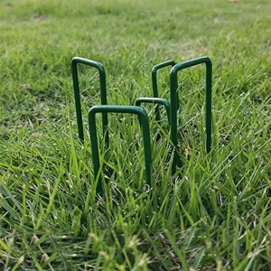 Grüne U-förmige Gartenpfähle zur sicheren Befestigung von Kunstrasen, Landschaftsbau und Pflanzen.