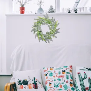 Artificial eucalyptus wreath door hanging, realistic green leaves for home decor and festive settings.