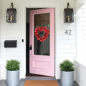 Red heart tinsel wreath hanging on door for Valentine's Day, wedding and home decor.