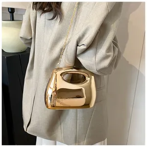 Shiny gold metallic acrylic evening bag with cutout handle and chain strap for stylish women.