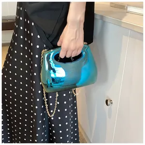 Detail view of stylish candy color acrylic hard shell clutch evening bag with metal chain strap.