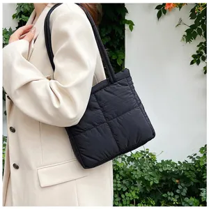 Black quilted puffer shoulder bag for women, trendy minimalist underarm commuter bag detail.