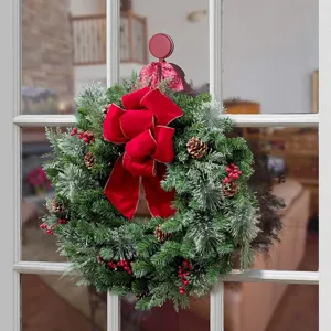Detailansicht eines Weihnachtskranzes an einer Glastür mit einem starken roten magnetischen Haken.