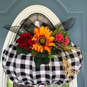 Ghirlanda di zucca a quadri bianco e nero con girasoli per decorazione della porta di casa autunnale.