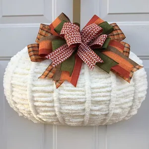 Vista dettagliata della decorazione da appendere in peluche di zucca lavorata a maglia.