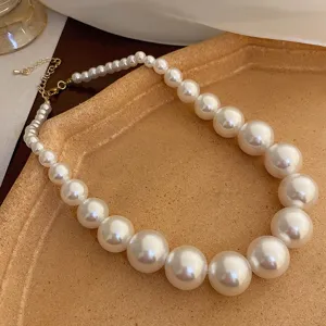 Elegant gradient pearl necklace detail shot, vintage chic gold chain jewelry for women.