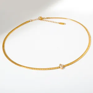 Detailopname van de gouden roestvrijstalen slangketting met een centrale marquisekristal.