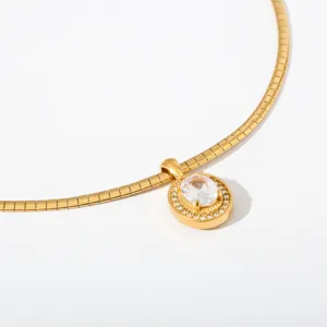 Gedetailleerd overzicht van gouden roestvrijstalen ketting met sprankelende kristallen hanger.