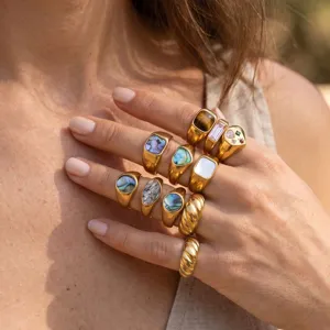 Primer plano detallado de anillos de oro elegantes con varias piedras preciosas, joyería de moda.