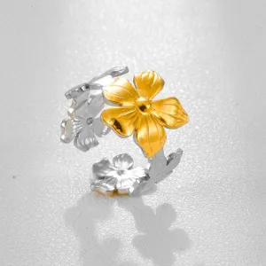 Primer plano detallado del anillo floral de acero inoxidable bicolor con textura fina.