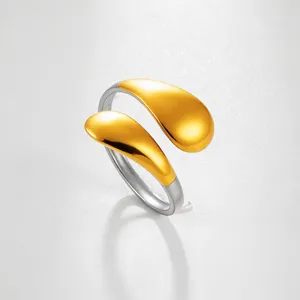 Vista detallada de un elegante anillo abierto bicolor de acero inoxidable con detalles dorados.