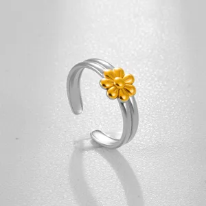 Primer plano del anillo ajustable bicolor de acero inoxidable con un lindo diseño de flor dorada.