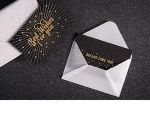 Detalle en primer plano de tarjeta de felicitación creativa negra y dorada con sobre elegante.