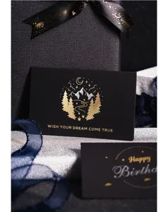 Primer plano detallado de tarjeta de felicitación negra de lujo con relieve en oro y plata.
