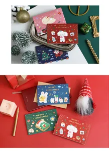 Weihnachtsgrußkarten Detailaufnahme mit süßen Cartoon-Illustrationen und Goldprägung-Designs.