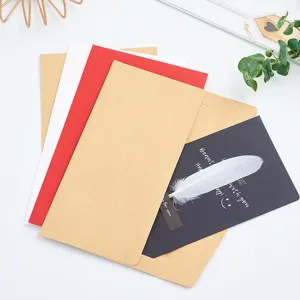 Kraft paper envelopes set with white and red options, greeting card and feather decor.
