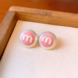 Pink enamel letter m stud earrings detail close up, stylish sweet chic jewelry for women.
