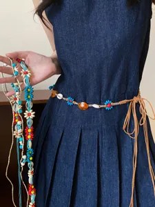 Bohemian woven waist chain detail view featuring colorful beads, natural shells and braided cord.