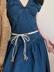 Bohemian woven waist belt with wooden flower beads and elegant bow tie design for women.