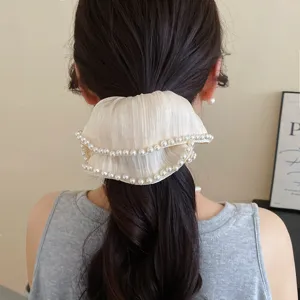 Gedetailleerd opname van een retro geplooide parelhaarband van gaas voor een elegante staart.