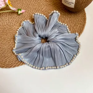 Vintage geplooide grijze haarscrunchie versierd met elegante parels, zacht stoffen haaraccessoire.