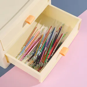 Colorful gel pen refills neatly arranged inside a cream plastic desktop storage drawer detail.