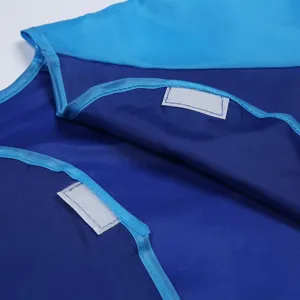 Close-up detail of waterproof painting apron fabric, blue nylon smock with velcro closure.