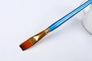 Gedetailleerd opname van een platte kunstenaarspenseel met blauwe steel en gouden huls.