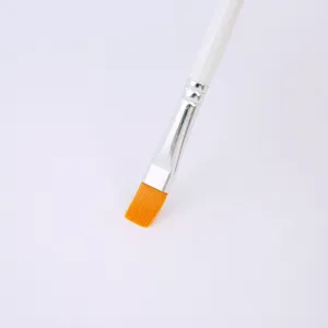 Close up detail view of artist flat paint brush with bright orange bristles and white handle.