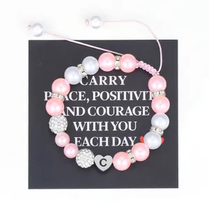 Handmade woven pink pearl bracelet with stainless steel initial heart charm for women.