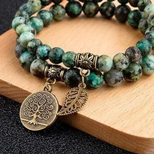Detail shot of double-layer natural stone beaded bracelet with tree of life pendant and leaf charms.