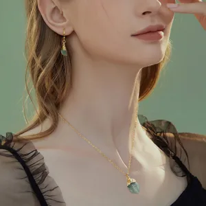 Elegante set di collana e orecchini in pietra naturale con ciondolo di cristallo irregolare.