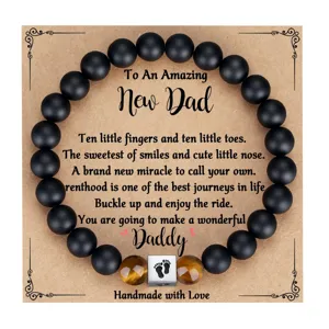 Matte black and tiger eye bead bracelet with footprint charm for new dad gift presentation.