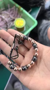 Vue détaillée d'un bracelet double tressé à la main avec perles d'hématite et or rose.