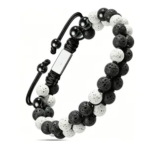 Vue détaillée du bracelet tressé en pierre de lave noire et blanche avec plaque métal.