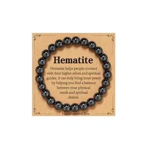 Detail shot of black hematite bead bracelet on kraft display card with spiritual text.