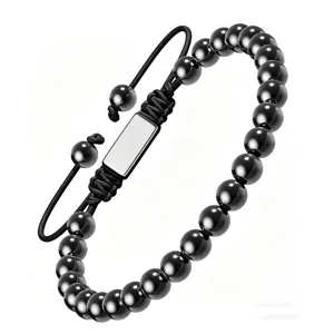 Gros plan détail du bracelet tressé en perles noires avec plaque en métal vierge cordon.