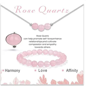 Dettaglio gioielli in quarzo rosa con collana delicata, anello e bracciale perle.