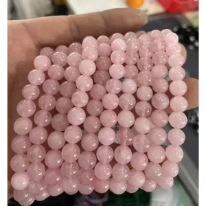 Vista detallada de los hilos de pulsera de cuentas de cuarzo rosa de 8mm, joyería de piedra.